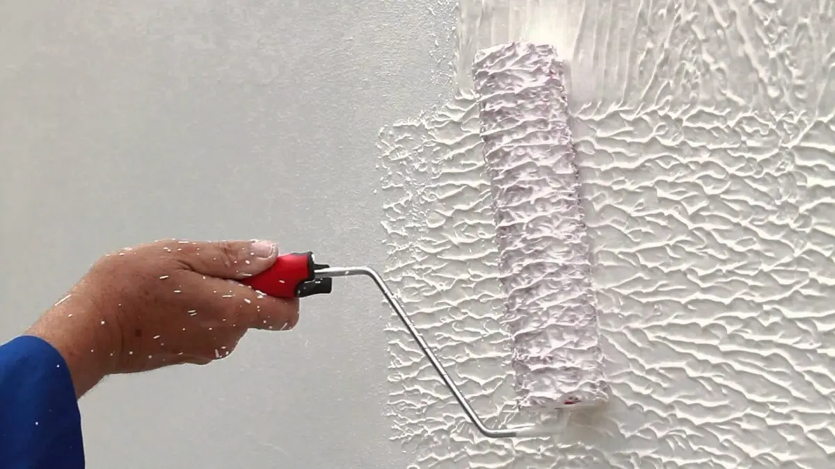 Homem pintando parede com textura